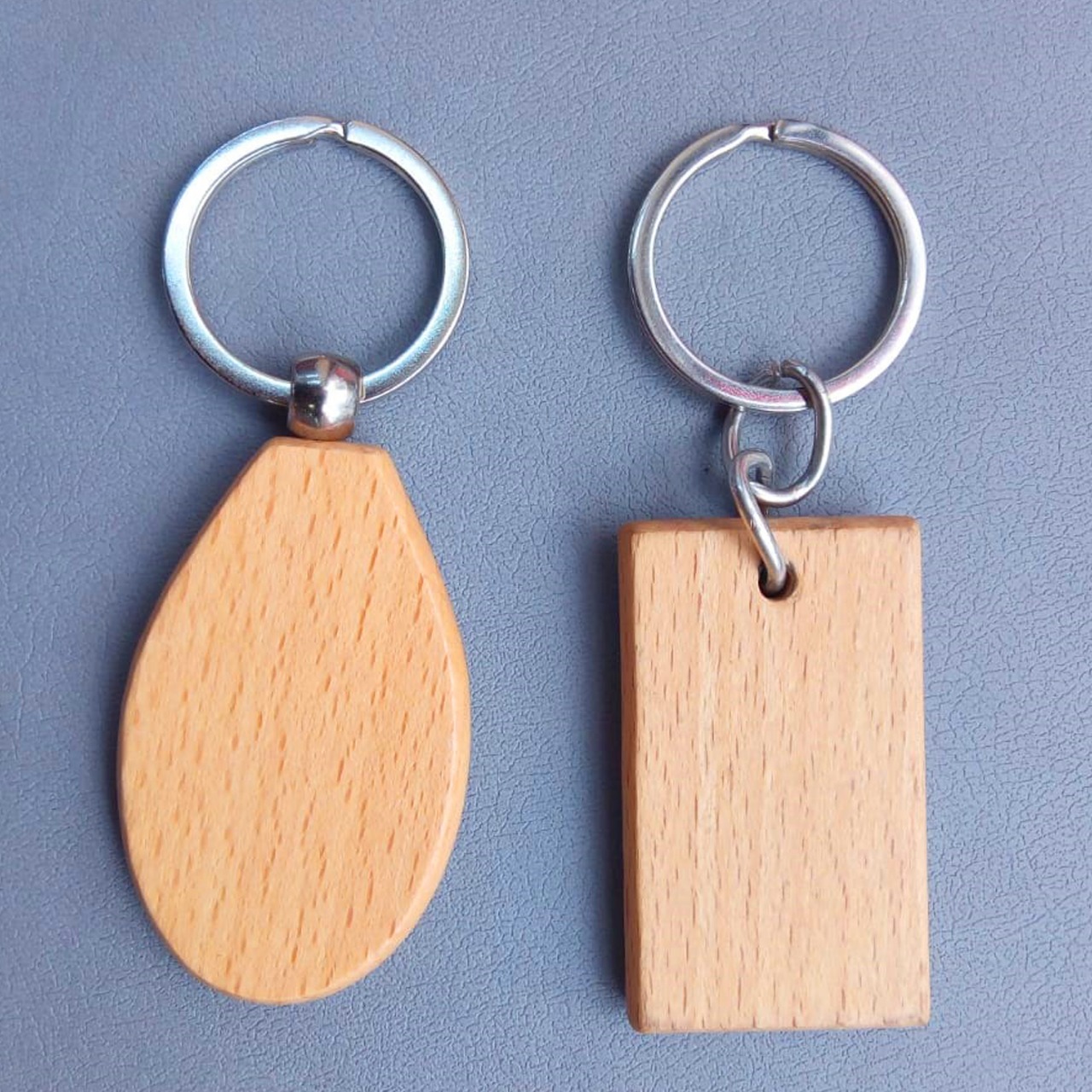 The wooden material used in their construction gives them a natural and rustic charm, while the metal key ring ensures durability and secure attachment to your keys.